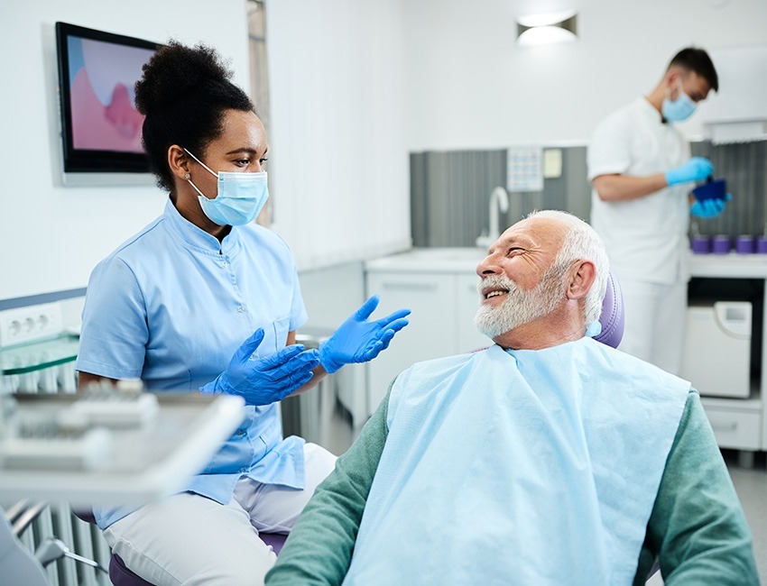 Un hombre mayor habla con su dentista.
